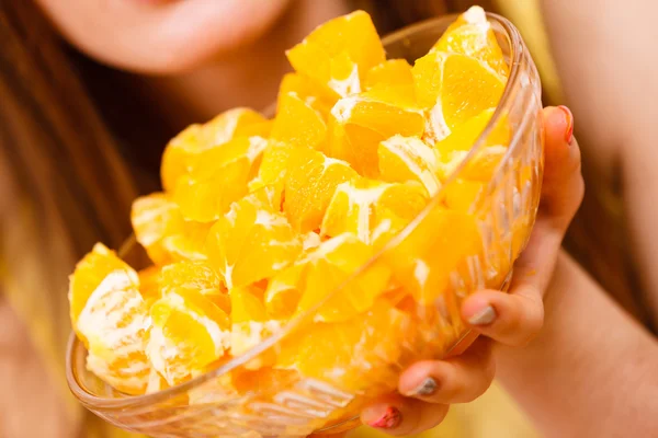 Жінка тримає миску повну нарізаних апельсинових фруктів — стокове фото
