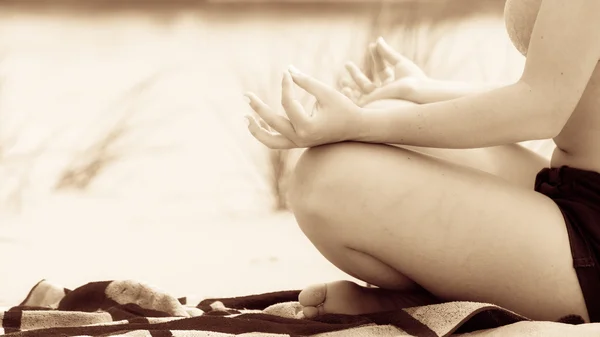 Vrouw doet yoga op zandstrand. — Stockfoto