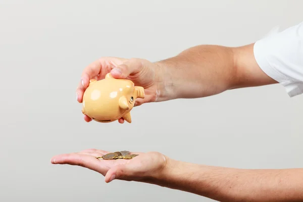 Male hands with coins and piggybank — Stock Photo, Image