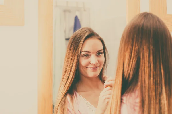 Kvinnan tar hand om hennes långa hår i badrum — Stockfoto