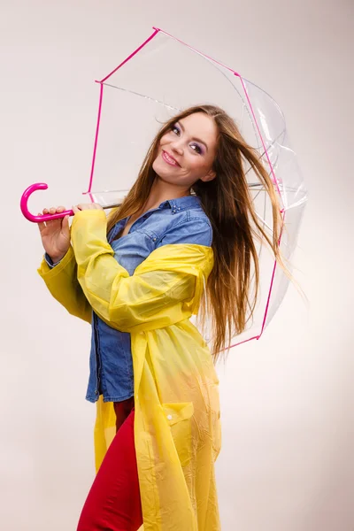 Frau trägt wasserdichten Mantel unter Regenschirm — Stockfoto
