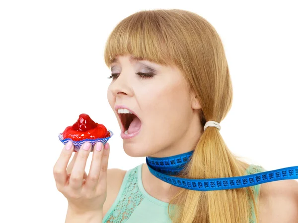 Frau hält Cupcake in der Hand und versucht der Versuchung zu widerstehen — Stockfoto