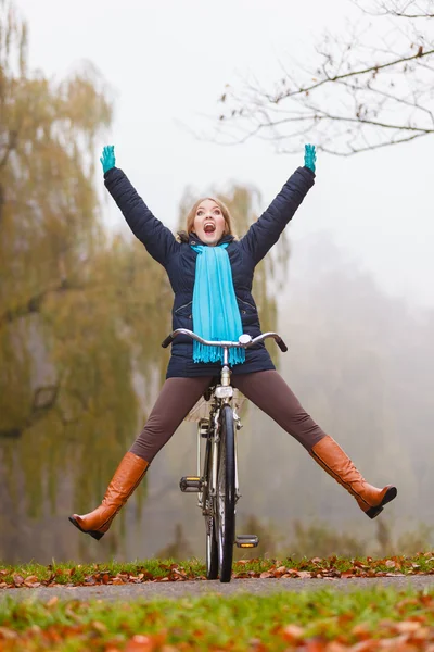 在秋天的公园里骑自行车开心的活泼女人 — 图库照片