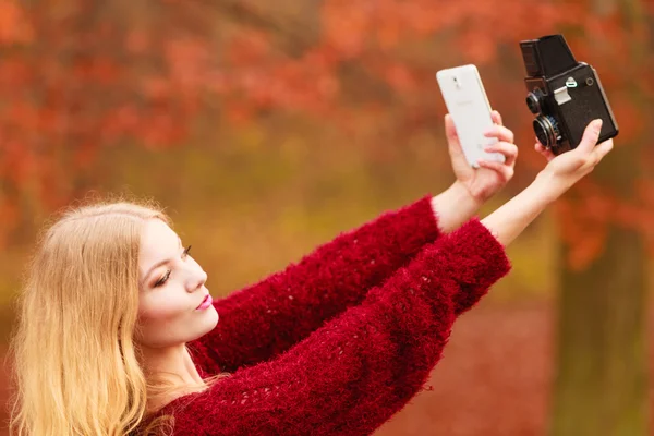 Kvinna med kamera och smartphone ta selfie Foto — Stockfoto