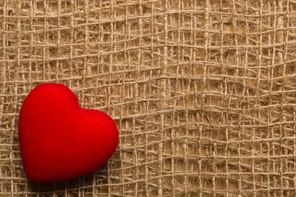 Красное сердце на абстрактном фоне ткани — стоковое фото