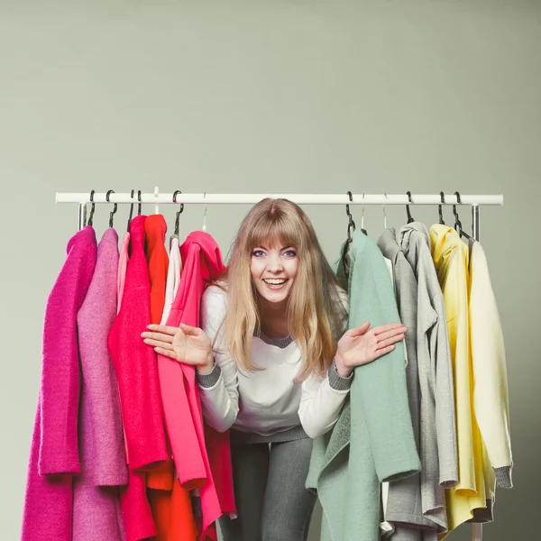 Kvinna som smyger bland kläder i mall eller garderob. — Stockfoto