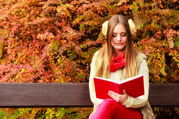 Frau entspannt sich im herbstlichen Park beim Lesen von Buch — Stockfoto