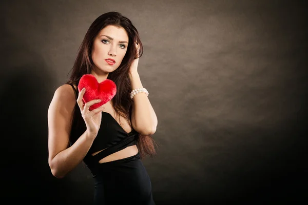Beautiful woman holds red heart on black — Stock Photo, Image