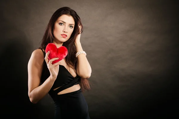 Mulher bonita detém coração vermelho no preto — Fotografia de Stock