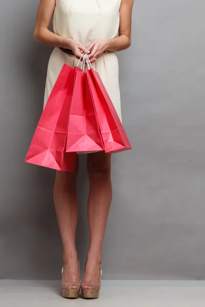 Vrouw met rode papieren boodschappentassen — Stockfoto