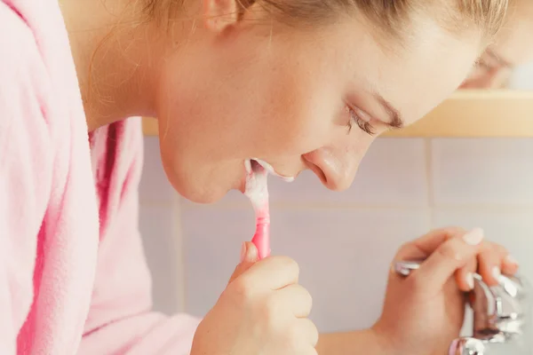 Donna spazzolatura pulizia dei denti in bagno — Foto Stock