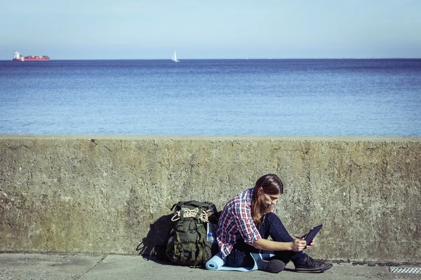 Man tourist backpacker sitting with tablet outdoor — Stock Photo, Image