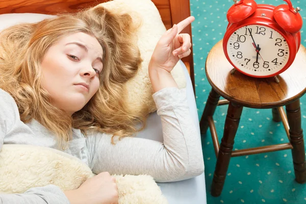 Woman waking up turning off alarm clock in morning — Stock Photo, Image