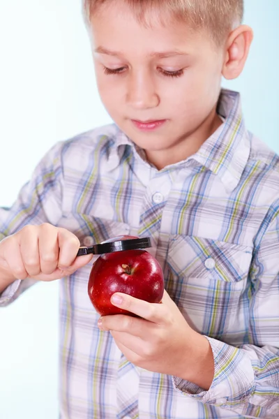 Kid examine apple with magnifying glass. — Stock Photo, Image