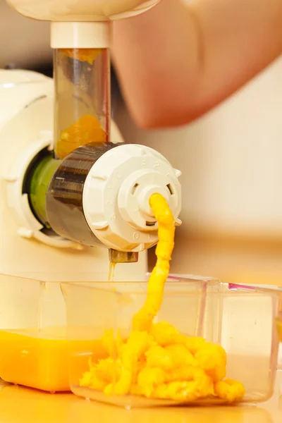 Vrouw maken van sinaasappelsap in juicer machine — Stockfoto