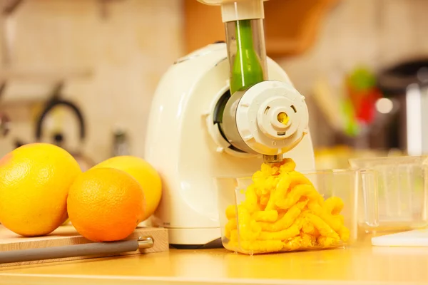 Het maken van jus d'orange in de juicer machine in keuken — Stockfoto