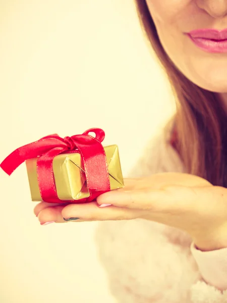 Mano femenina con regalo de caja dorada — Foto de Stock
