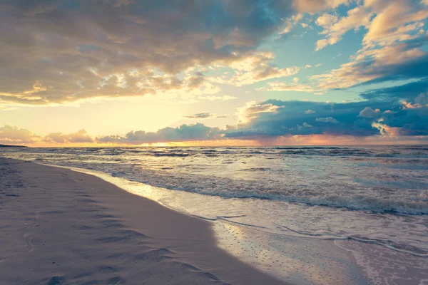 Pôr do sol beatiful com nuvens sobre o mar e a praia — Fotografia de Stock