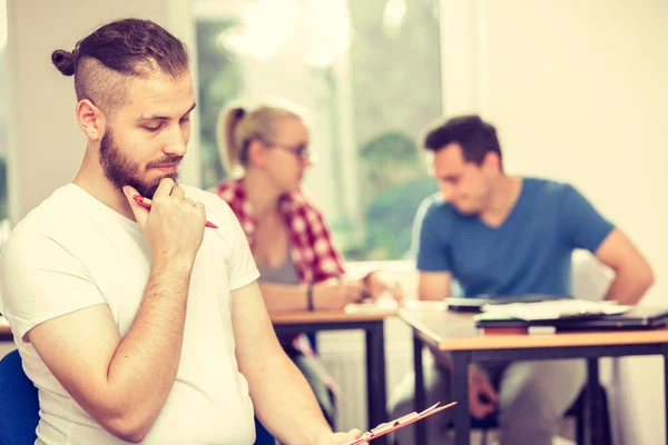 Student jongen voor haar stuurlieden in klas — Stockfoto