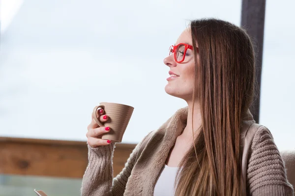 自宅でコーヒーを飲みながらリラックスした笑顔の女性 — ストック写真