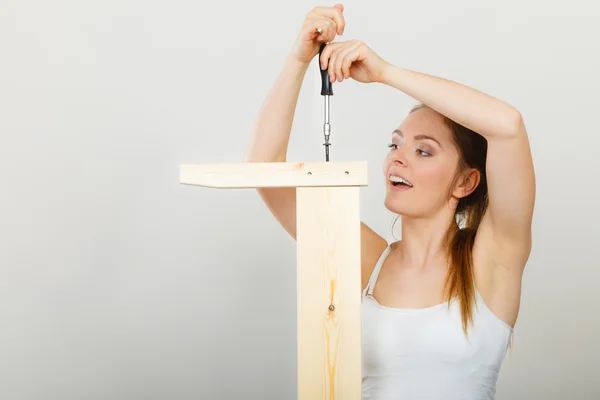 Frau beim Zusammenbau von Holzmöbeln. Heimwerken. — Stockfoto