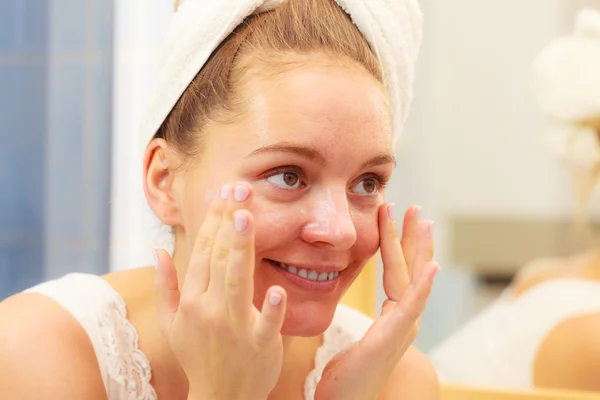 Γυναίκα εφαρμογή κρέμας μάσκα στο πρόσωπο στο μπάνιο — Φωτογραφία Αρχείου