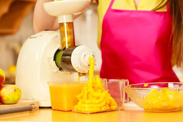 Kvinna att göra apelsinjuice i juicepress maskin — Stockfoto