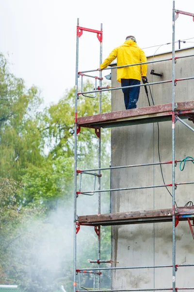 Un homme nettoie un mur. Échafaudages — Photo
