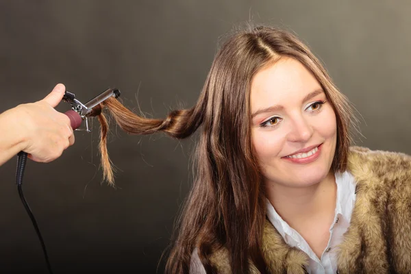 Stylista curling włosy dla młodej kobiety. — Zdjęcie stockowe