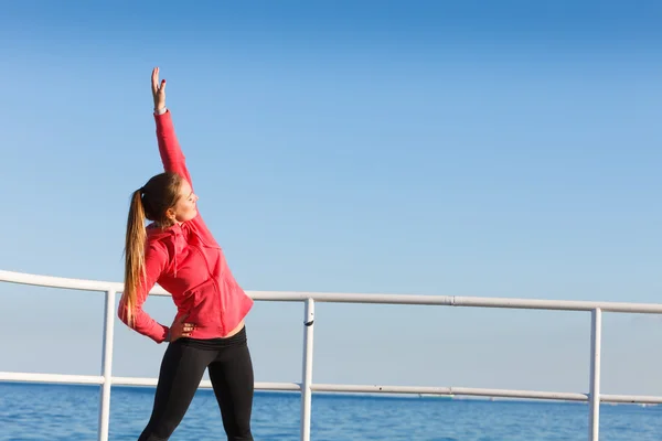 Woman doing sports exercises outdoors by seaside — Stock Photo, Image