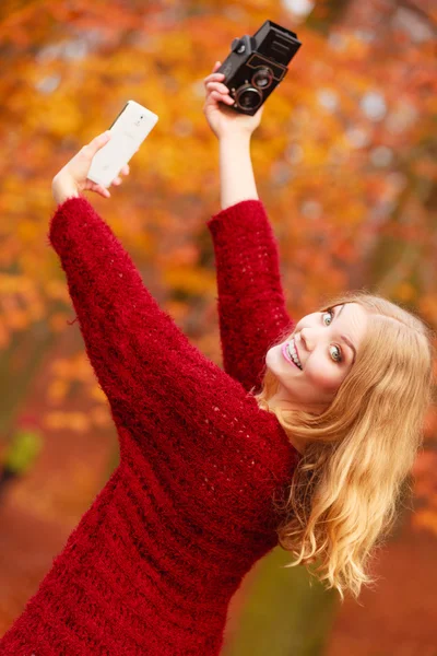 Kvinna med kamera och smartphone ta selfie Foto — Stockfoto