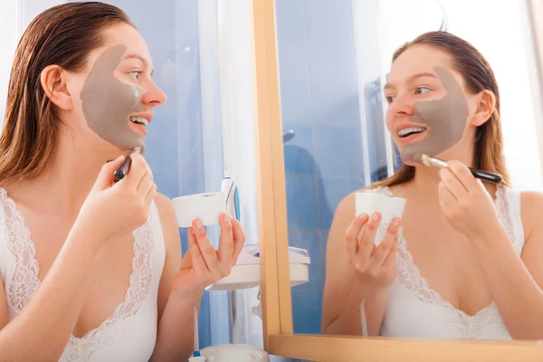 Woman applying mud facial mask — Stock Photo, Image