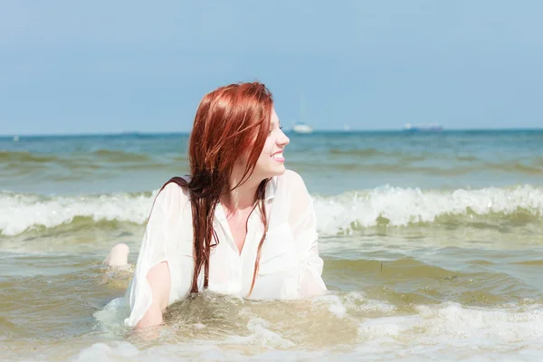 Sensueel meisje natte doek in het water aan de kust. — Stockfoto
