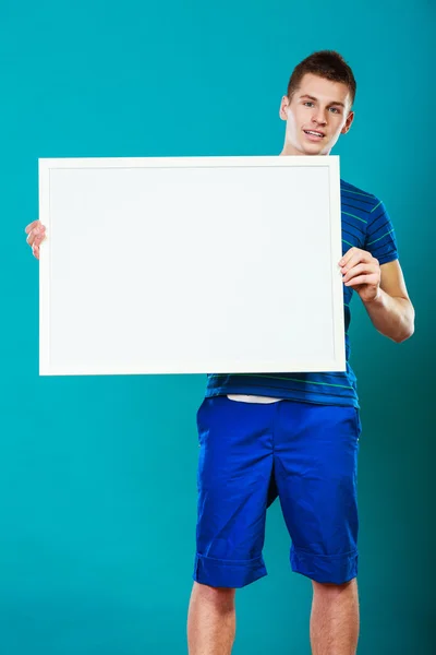 Homem segurando placa de apresentação em branco no azul — Fotografia de Stock