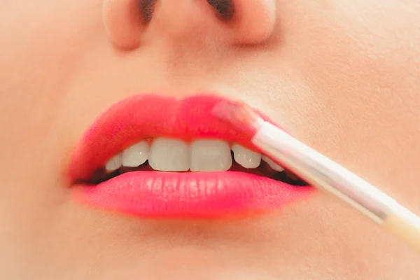 Vrouw die lippenstift met borstel op de lippen aanbrengt. Make-up — Stockfoto