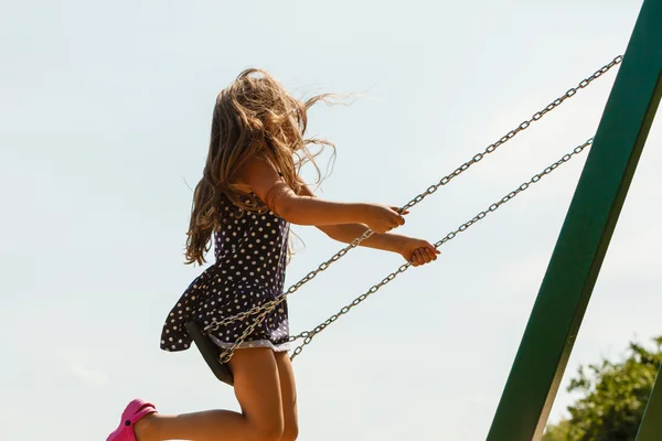 Chica balanceándose en swing-set . — Foto de Stock