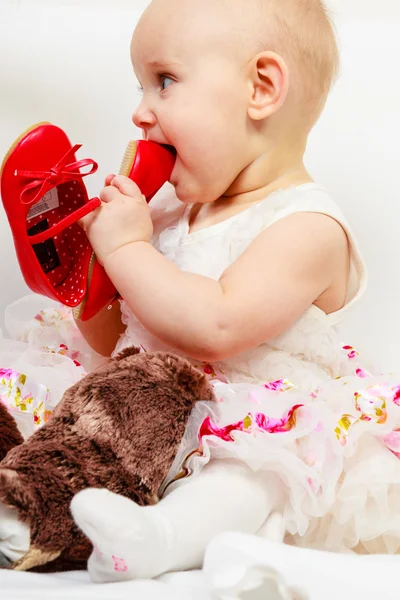 Baby girl biting shoe — Stock Photo, Image