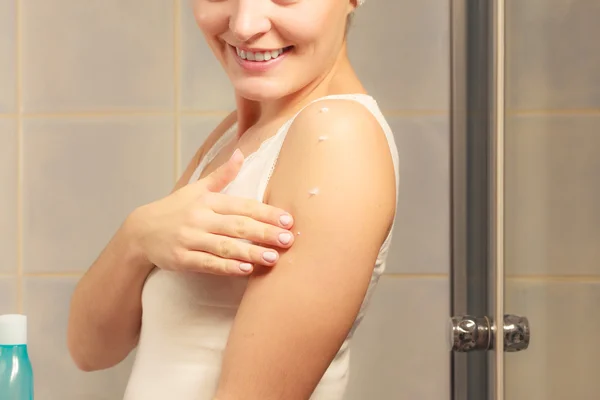 Mulher aplicando creme hidratante em seu corpo — Fotografia de Stock