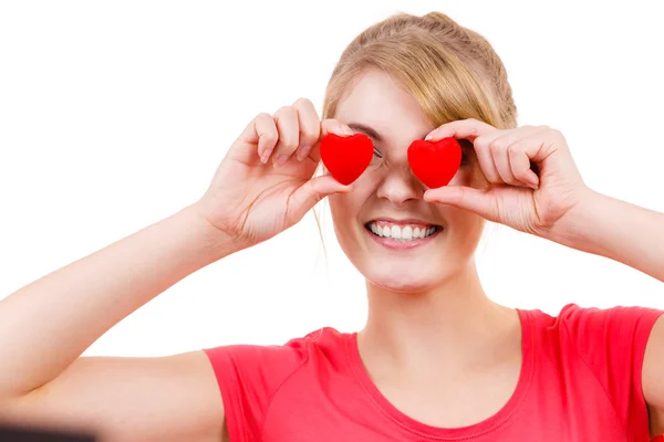 Mujer divertida sostiene corazones rojos sobre los ojos —  Fotos de Stock