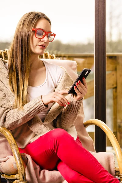 Woman sitting on chair using phone at home — Stock Photo, Image