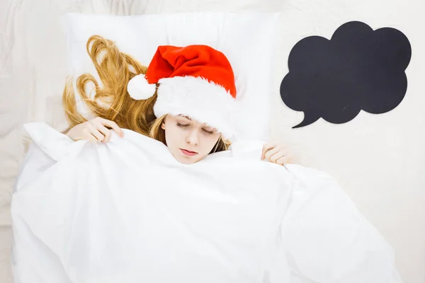 크리스마스 시즌을 기다리는 잠자는 잠옷을 산타클로스 모자를 침대에 휴일을 축하하는 — 스톡 사진