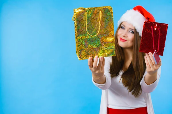年轻的黑发女人乐于送圣诞礼物 头戴圣诞礼帽的女性带着节日礼品袋 — 图库照片