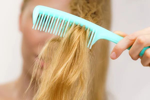 Mulher Loira Com Pente Escovando Seu Cabelo Muito Longo Bagunçado — Fotografia de Stock