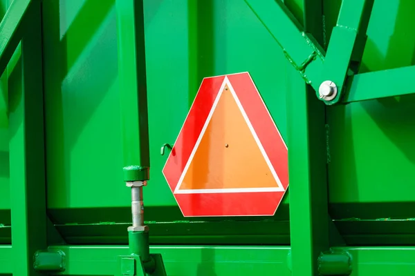 Detail industry agricultural machine with reflective slow moving vehicle warning sign in triangle shape