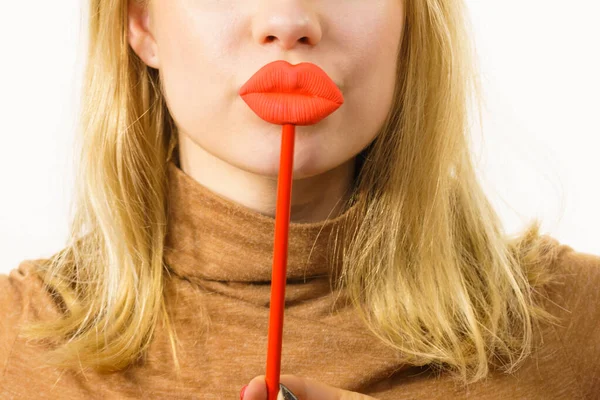 年轻的女人紧紧抓住大大的红色假嘴唇Lip Injection Beauty Standards Concept — 图库照片