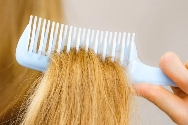 Mulher Loira Com Pente Escovando Seu Cabelo Muito Longo Bagunçado — Fotografia de Stock