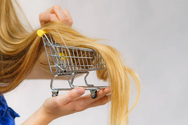 ショッピングカートで彼女の長いブロンドの髪の女の子 ヘアカットヘアケアとショッピングのコンセプト — ストック写真