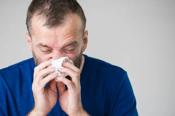 インフルエンザにかかり 衛生的な組織にくしゃみをする男 奴は病気で鼻を吹いてアレルギーがある — ストック写真