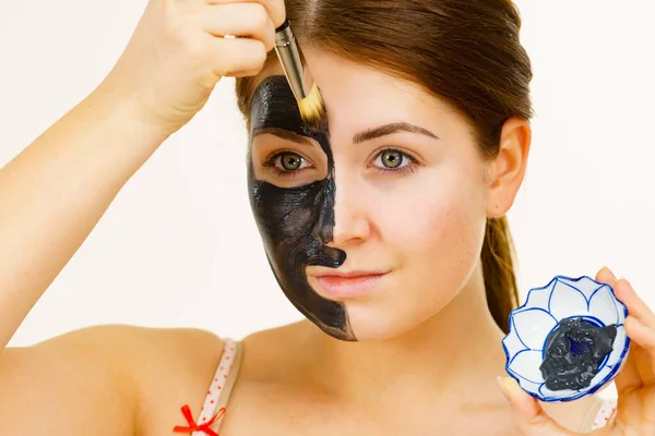 スキンケアだ 泥のカーボマスクを適用する女性 彼女の顔に深いクレンザー 女性は黒い粘土化粧品とブラシとボウルを保持しています にきび治療 — ストック写真