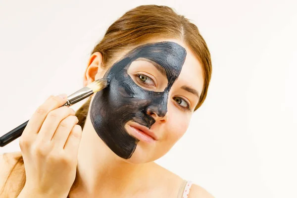 スキンケア 女性は ブラシを使用して 黒い浄化泥マスク 彼女の顔に深いクレンザーを適用します にきび治療 — ストック写真